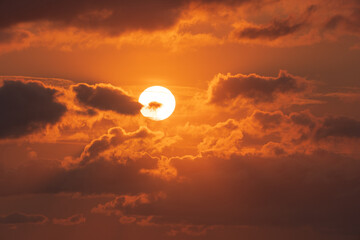 Deep orange colorful sun with clouds close to sunset. Nature background.