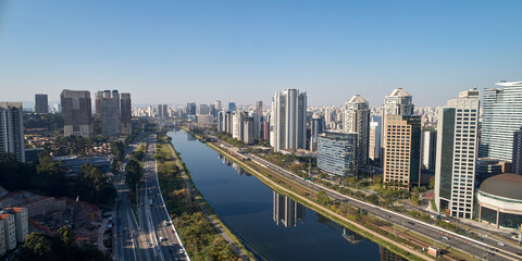 Aerial view of Marginal Pinheiros avenue, Pinheiros river, modern buildings in Sao Paulo city on a sunny day.