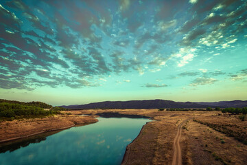 Lake reflecting a cloudy sky on a plain