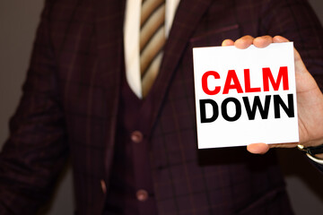 Blackboard with calculator, notebook, ball pen and sunglasses on wooden table. CALM DOWN.