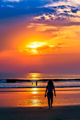 Fototapeta premium Silhouetted Woman on Beach at Sunset 