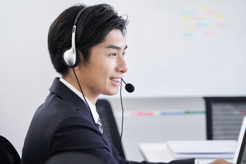 オフィスでお問い合わせに答える日本人男性ビジネスマン