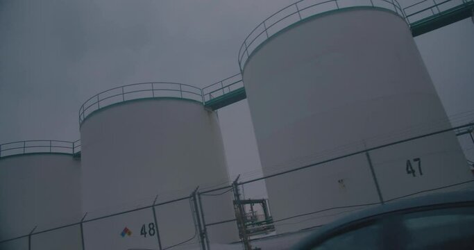 Montreal, QC, Canada - November 15, 2017: Worm eye, Dutch angle view of Oil refineries storage tanks, filmed while driving near Montreal East Refinery