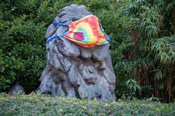 Bronze sculpture of a lion wears a face mask at the entrance to the National Zoo in Washington, DC.