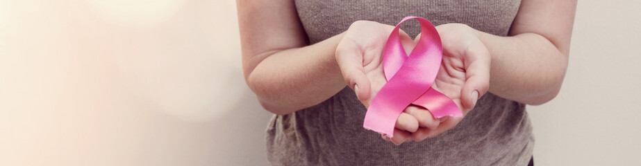 woman hands holding pink ribbon, breast cancer awareness, October pink concept