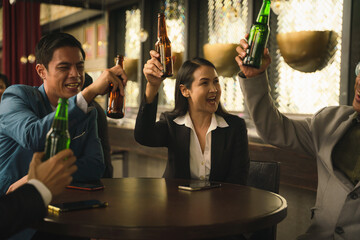 businesspeople toasting and clinking bottle of beer together