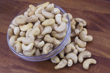 Cashew nuts in glass bowl on wooden table