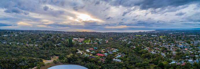 Aerial panorama of Mornington Peninsula ona cloudy day at sunset. Suburban area with trees and Port...