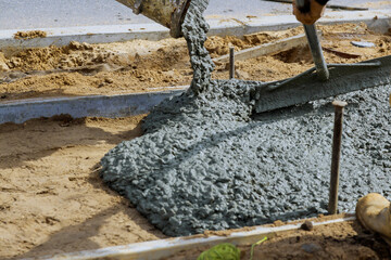 Workers concrete mixer with pouring cement during to residential on sidewalk