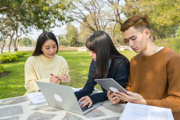 Group Teen asian student working with computer laptop outdoor university campus green park concept