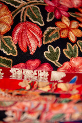 Kashmiri embroidered wool shawls folded in a stack. 