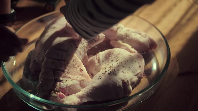 Putting Some Dried Herbs And Spices For Added Flavor On Chicken Legs At The Microwavable Glassware. - Close Up Shot