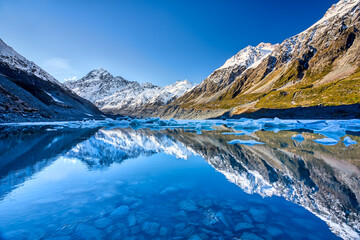 Fototapeta na wymiar Hooker lake with snow capped Mount Cook in the distance reflecting in the lake and a beautiful clear blue sky