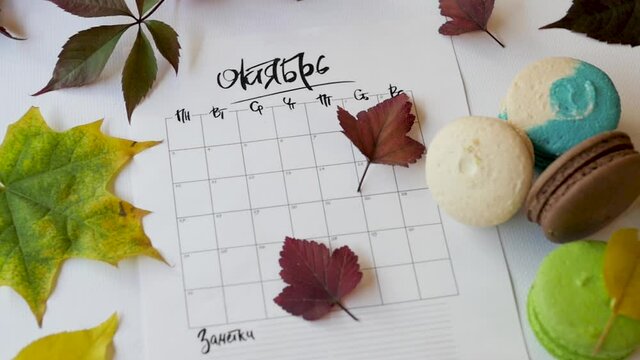 top view of the composition from the calendar of pasta and autumn flies. Autumn, yellow leaves, the word October