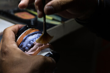 Adding more texture and finishing the prosthetic with a brush.