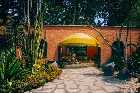 Bogor, Indonesia - A view of the flower themed park Taman Bunga Nusantara in an afternoon with a view to a typical mexican structure in peach walls and cacti in the entrance.