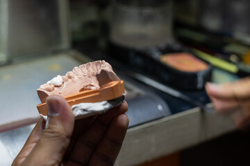 Dental laboratory prosthetic tooth being check
