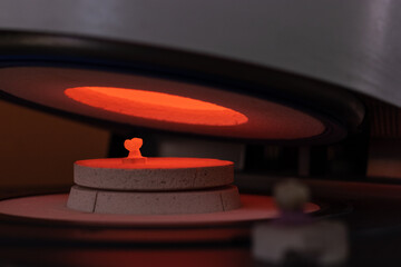 Man working in a prosthetic ceramic tooth cooking it.