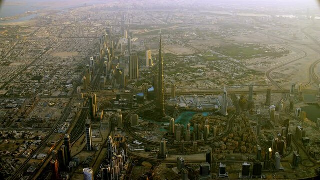 n astonishing aerial shot of the Burj Khalifa overlooking the Sheikh Zayed Road and its first interchange during the day, zoom in, 6-axis stabilized gimbal, Shotover F1, 8K.