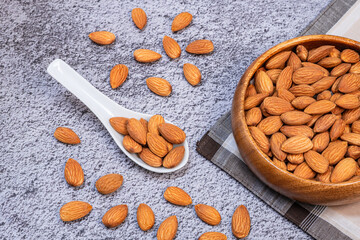 Almonds seed in a wooden bowl on dark background. Healthy food for peple who want to lose weight.