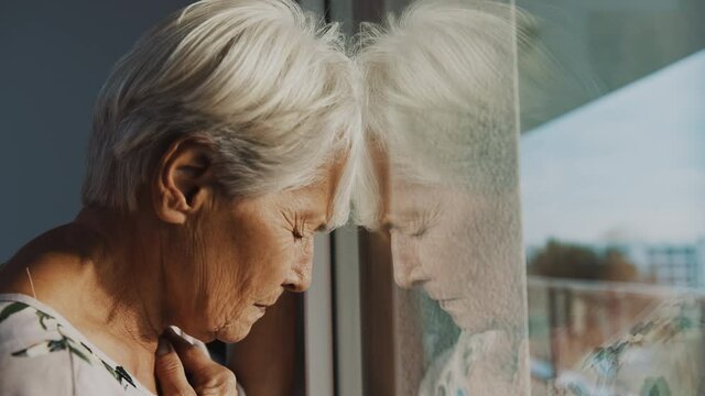 hopeless elderly woman, feeling loneliness during the lockdown. Vulnerable group and mental health issues. High quality 4k footage