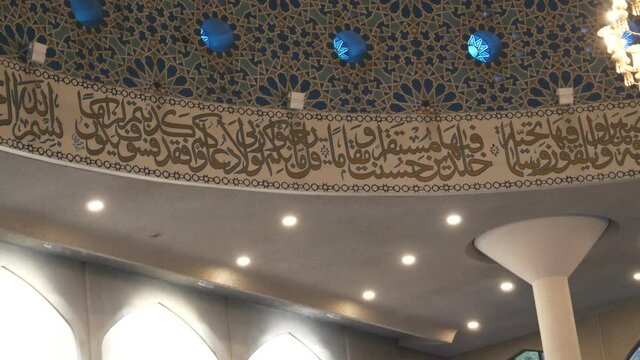 Arabic calligraphy inside of a mosque dome.