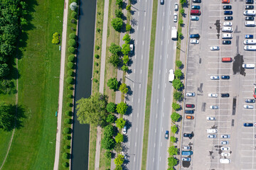 city road between parking lot and water canal. aerial top view from flying drone