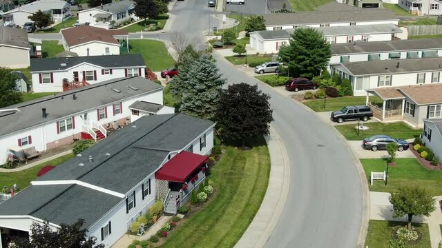 Aerial tilt up reveals new modular homes, mobile homes in neighborhood community, low income housing in United States of America, establishing shot by drone