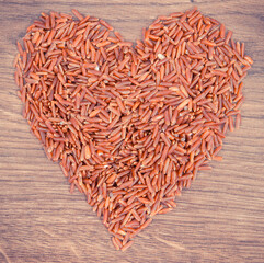 Vintage photo, Heart shaped red rice on rustic board