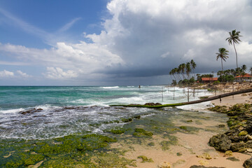 Distant traditional pole or stilt fishermen on a stormy day in Koggala, on the south west coast of Sri Lanka.