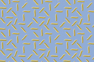 Fusilli pasta random flat lay on blue background without shadow. can be used as raw pasta background, poster, banner not pattern.