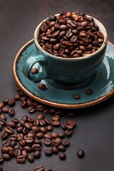 Coffee cup with roasted beans on stone background