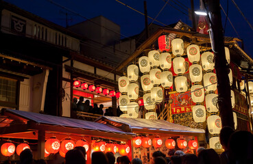 Nachtansicht von Yamahoko-Schwimmer mit Laternen und Menschen, die beim Gion Festival in Kyoto, Japan, Musik hören