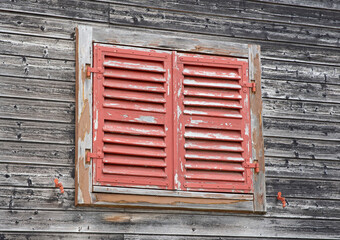 Old red shutters on a wooden wall