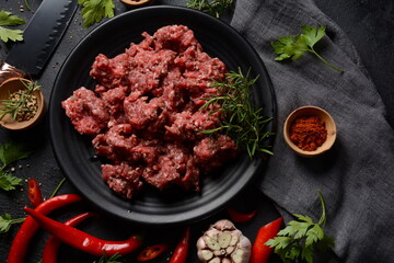 Minced beef. Ground meat with ingredients for cooking on black background
