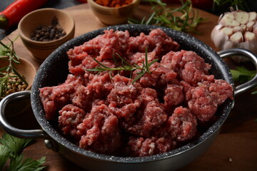 Minced beef. Ground meat with ingredients for cooking on black background