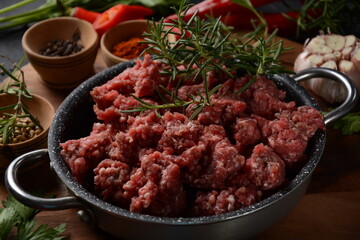 Minced beef. Ground meat with ingredients for cooking on black background