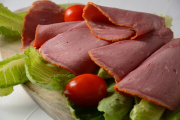 Peppered roast beef pastrami slices on lettuce leaf