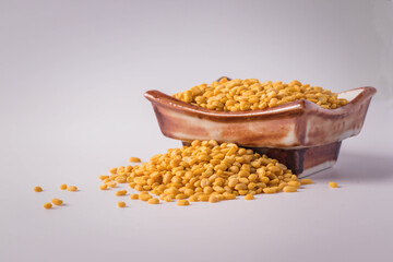 Fototapeta na wymiar Hulled split mung bean in brown cup on white background