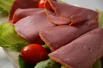Peppered roast beef pastrami slices on lettuce leaf