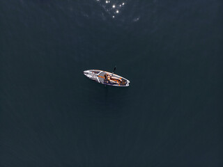 Naklejka premium Attractive Woman on Stand Up Paddle Board, Woman paddling on sup board and enjoying turquoise transparent water. Tropical travel, wanderlust and water activity concept. Sunset and relax