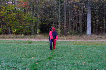 Halloween holiday concept.Scary Jester Costume.Creepy clown in a skull mask in a in green field on...
