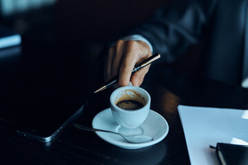 Business man in a cafe documents a cup of coffee on the table official work