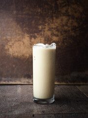 Glass of iced coffee on wooden background