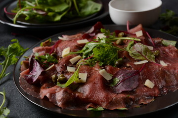 Beef Carpaccio  with parmesan, capers and arugula. With olive oil and soy sauce