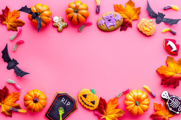 Frame of Halloween decorations with cookies and candies, top view