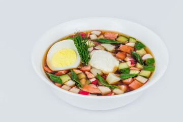 Okroshka in a white round plate shot on a white background