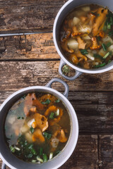 soup with chanterelles and herbs in two bowls