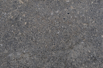 Abstract background of black asphalt with inclusions of pebbles