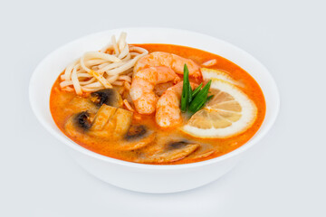 Tom Yam soup in a white plate on a white background
